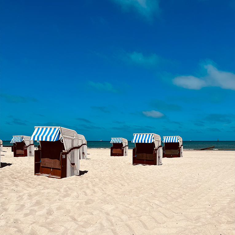 Strandkörbe unter weitem Himmel – ein Ort, an dem Entspannung sofort beginnt.