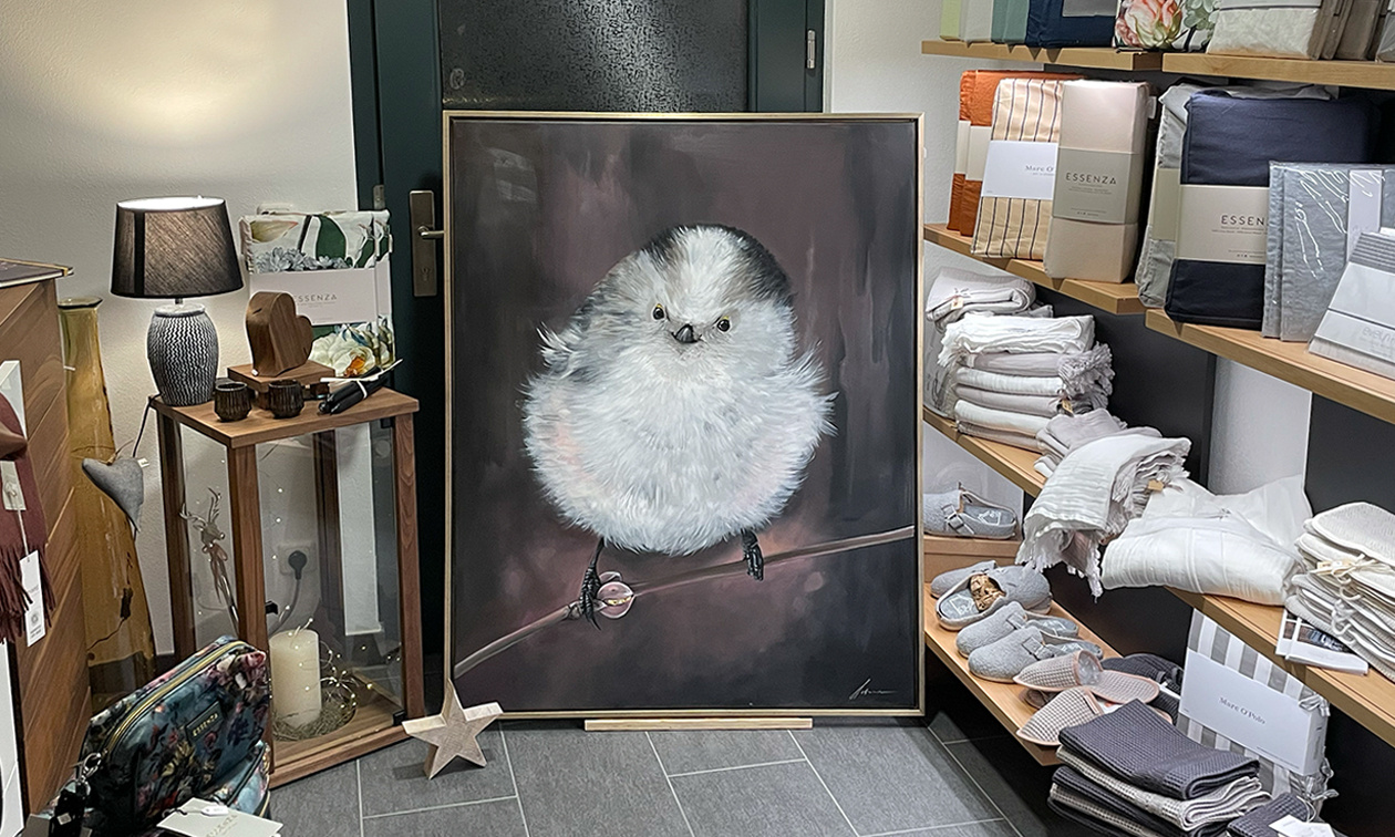 Der Flauschvogel hier ist eine „kleine Schwanzmeise“, ein heimischer Vogel, der ruhige Waldgebiete liebt. Jungvögel haben – abhängig vom Federkleid – häufig ein Grinsen im Schnabel. Interpretiert es nach eurem Gefühl.